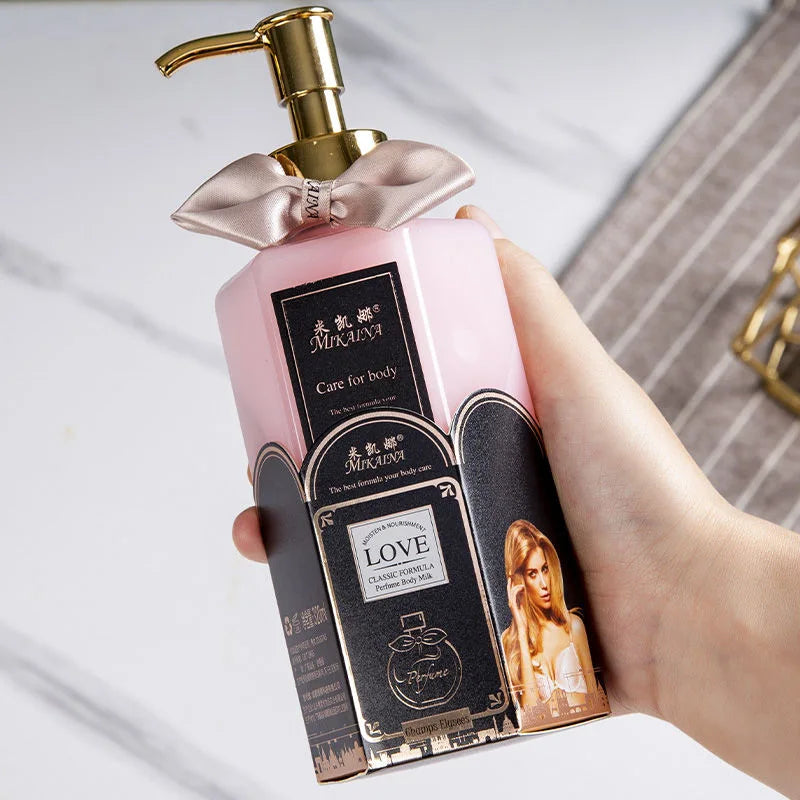 Chai nhựa màu hồng nhạt với vòi vàng, có nơ và nhãn đen hình ảnh người phụ nữ, cầm trong tay.