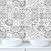 Bức tường lát gạch hoa văn xám trắng phức tạp, phía trước là hai bồn rửa tròn trắng.