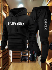 Bộ đồ nỉ đen có chữ "EMPORIO" trắng, treo trong phòng thay đồ gỗ sáng.