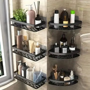 Kệ góc phòng tắm bằng kim loại đen với nhiều chai lọ và cây xanh trên nền gạch sáng.