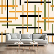 Ghế sofa xám nhạt trước tường họa tiết sọc ngang dọc màu cam, đen, xanh và kem.