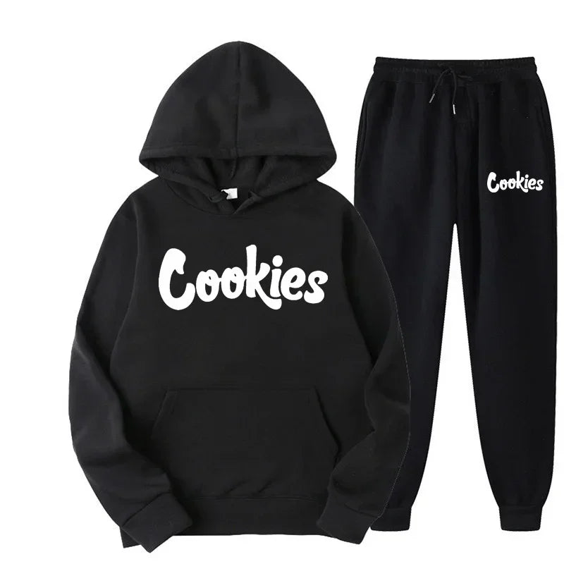 Bộ đồ đen có chữ "Cookies" trắng, gồm áo hoodie và quần dài, kiểu dáng thể thao.