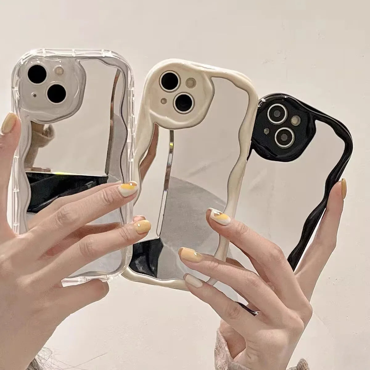 Ba ốp lưng điện thoại màu trắng, kem và đen, có viền gợn sóng và lỗ camera lớn.