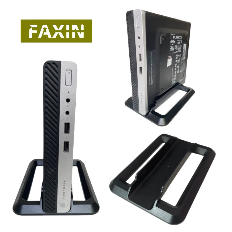 Máy tính mini màu bạc, đen, đứng trên đế nhựa, logo "FAXIN" nền xanh.