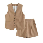 Bộ vest màu nâu nhạt gồm áo gi-lê cài nút đen và quần short, thiết kế đơn giản, lịch sự.