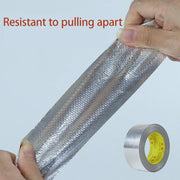 Băng dính bạc kim loại được kéo căng, dòng chữ đỏ "Resistant to pulling apart".