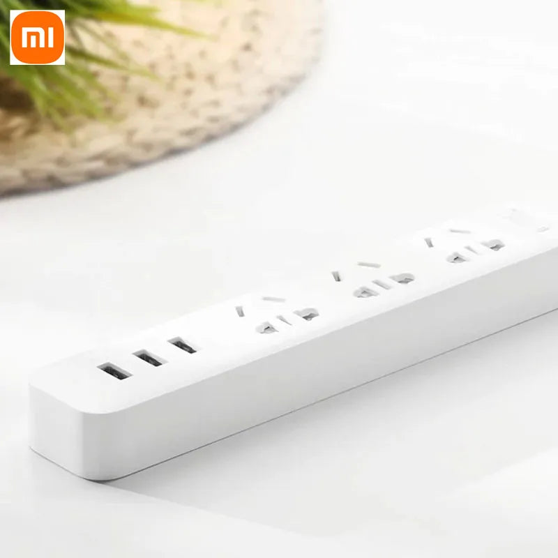 Ổ cắm điện màu trắng có ba cổng USB và ba ổ cắm điện trên bề mặt màu trắng.