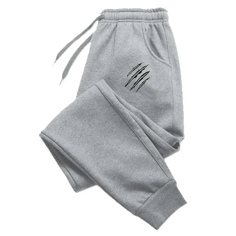 Quần jogger xám có túi và họa tiết vết cào đen bên trái.