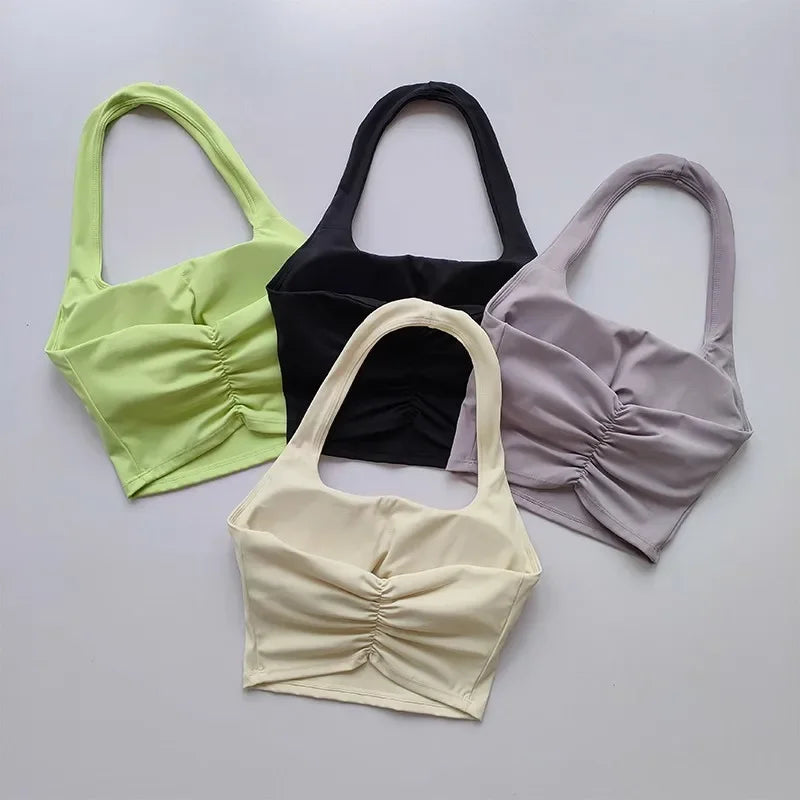 Bốn áo crop top, màu xanh lá, đen, tím nhạt, và kem trên nền trắng.