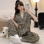 Người mặc đồ ngủ họa tiết da báo, chụp ảnh tự sướng trong phòng sáng, có đèn và ghế.