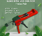 Súng bơm keo màu đỏ và xanh lá, nền xanh với lá cây trang trí.